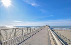 a boardwalk leading to the beach on a sunny day at 3 Bedroom Cozy Home In Piano Di Mommio in Piano di Mommio
