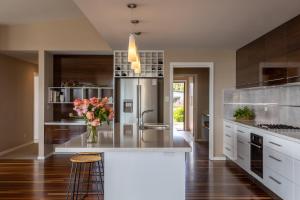 a kitchen with a large island with a vase of flowers at River Haven serene spacious with river views in Launceston