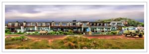 un grande edificio con due camion parcheggiati di fronte di Mitford Holiday Flats a Morgan's Bay