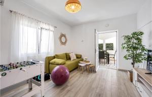 a living room with a green couch and a table at Stunning Home In Rogoznica in Rogoznica