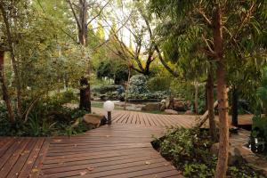 a wooden walkway in a park with a lamp on it at Jedidja Bed and Breakfast in Bloemfontein