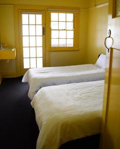 three beds in a room with two windows at Grafton Hotel in Grafton +10 photos