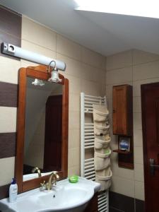a bathroom with a sink and a mirror and towels at La Mos Pavel in Noşlac