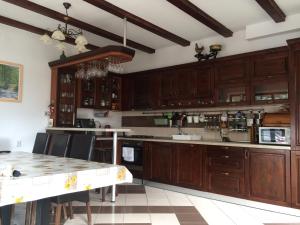 a kitchen with wooden cabinets and a table at La Mos Pavel in Noşlac