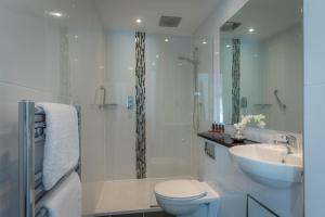 un bagno bianco con un water e un lavandino di The Fleet a Dublino Altre 37 foto