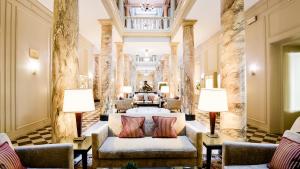 沃韦Hôtel Des Trois Couronnes & Spa - The Leading Hotels of the World的酒店大堂设有两把椅子和一张沙发