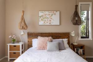 a bedroom with a white bed with a wooden headboard at River Haven serene spacious with river views in Launceston