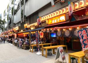 a group of people sitting at tables outside a restaurant at Hotel SUNROAD Adult Only in Tokyo