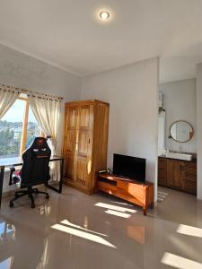 a room with a chair and a desk and a television at Kanaka 2 storey House Nusadua in Badung