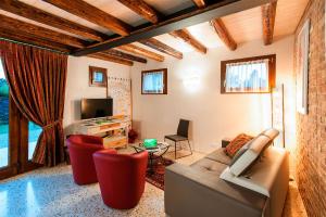 a living room with a couch and chairs and a tv at Brick House Silea in Silea
