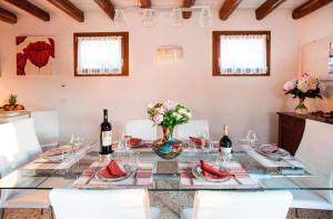 a dining room with a glass table with wine bottles at Brick House Silea in Silea