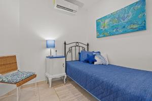 a bedroom with a blue bed and a chair at Sunshine Escape with a Rooftop Patio in Coco +30 photos