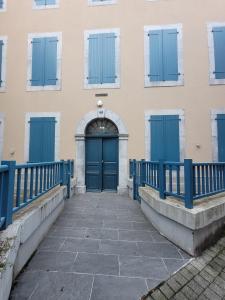a blue door on a building with windows at L HELIOS Centre ville 1 chambre in Cauterets