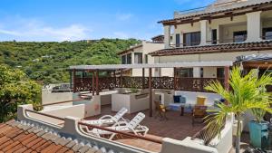 a balcony of a house with chairs and tables at Sunshine Escape with a Rooftop Patio in Coco