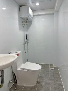 a white bathroom with a toilet and a sink at Ngọc Khánh Hotel in Da Lat