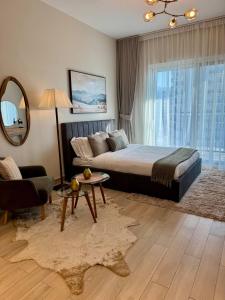 a bedroom with a bed and a couch and a mirror at Waterfront Heaven Studio Yas Island in Abu Dhabi