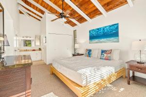 a bedroom with a bed and a ceiling fan at Beautiful Airy 1 Br Condo with Loft Golf Course View Pool Hot tub 209A in Princeville +16 photos