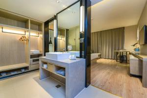 a large bathroom with a sink and a tub at Echarm Hotel Guiyang Municipal Government Lin Cheng Xi Road Metro Station in Guiyang
