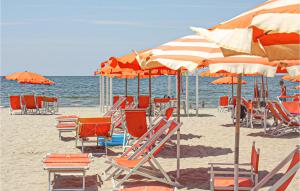- un bouquet de chaises et de parasols sur une plage dans l'établissement Cozy Apartment In Lido Di Camaiore, à Lido di Camaiore 13 autres photos