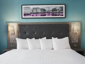 a bedroom with a large bed with white pillows at Leonardo Hotel Liverpool - formerly Jurys Inn in Liverpool