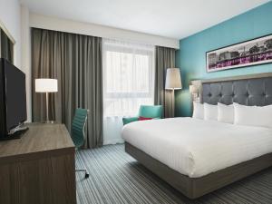 a hotel room with a large bed and a large window at Jurys Inn Liverpool in Liverpool