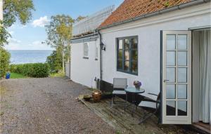 a small white house with a table and chairs at Stunning Apartment In Svaneke in Svaneke