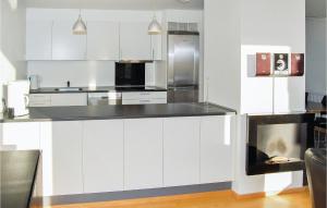 una cucina con armadietti bianchi ed elettrodomestici in acciaio inossidabile di Apartment Nordre Havnevej Rømø a Havneby