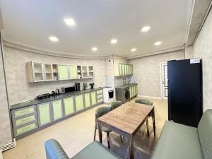 a large kitchen with a wooden table and chairs at Nizami Luxury Apart in Baku