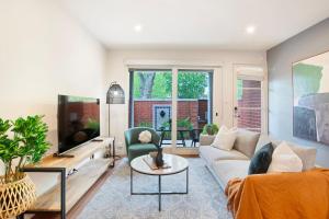 Una sala de estar con un sofá y un televisor. en Splendour in Norwood, en Kensington and Norwood