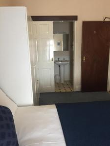 a bathroom with a bed and a sink in a room at Marlow Lodge in Blackpool
