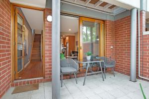 a patio with a table and chairs on a brick building at Splendour in Norwood in Norwood