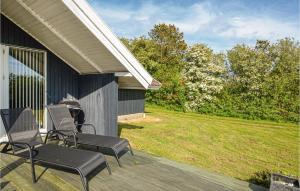 a porch with chairs on a house with a yard at Holiday Home Gunhildsvej Vestervig in Vestervig +10 photos