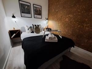 een slaapkamer met een bed met zwarte lakens en kussens bij Gryfny Grubiorz in Katowice