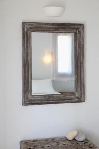 un espejo en la pared junto a la cama en Casa Kalypso Suites & Villa, en Steni Vala Alonissos