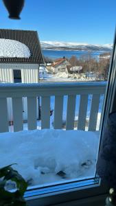 a snow covered balcony with a view of the water at Stor hybel in Tromsø +1 photo