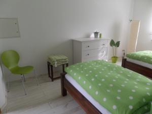 a bedroom with a bed and a dresser and a chair at Elbflair in Zahna-Elster