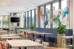纽尼顿Hampton By Hilton Nuneaton的有桌椅和窗户的餐厅