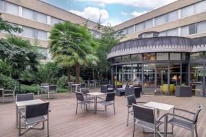 布吉瓦尔DoubleTree by Hilton Paris Bougival的建筑物前有桌椅的露台