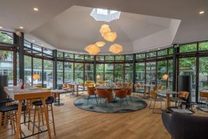 布吉瓦尔DoubleTree by Hilton Paris Bougival的有桌椅和窗户的餐厅
