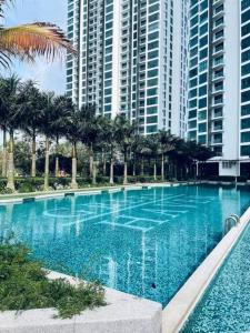 a large blue swimming pool in front of tall buildings at Green Haven Unique Relaxing Home & Netflix in Masai