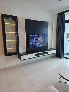 a living room with a flat screen tv on a wall at Green Haven Unique Relaxing Home & Netflix in Masai