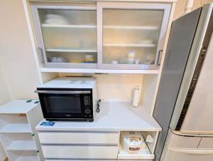 een magnetron op een aanrecht in een keuken bij メイプルヒルイン府中多磨 in Fuchu