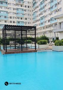 a large swimming pool in front of a large building at Marina Oasis Two Bed Room Condo Unit in Dumaguete +12 photos