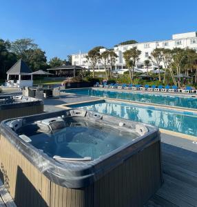 a hot tub on a deck next to a swimming pool at Westhill Country Hotel in Saint Helier Jersey