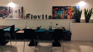 a restaurant with two tables and a sign on the wall at Giovita Room and Suite Centro Sicilia in Caltanissetta