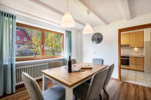 une cuisine et une salle à manger avec une table et des chaises en bois dans l'établissement Naturzeit, à Königsfeld im Schwarzwald