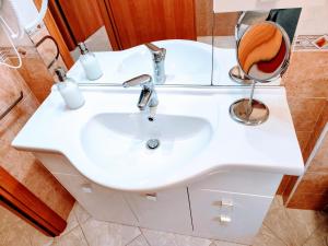 un bagno con un lavandino bianco e uno specchio di Apartment RSK by the sea a Lido di Ostia Altre 31 foto
