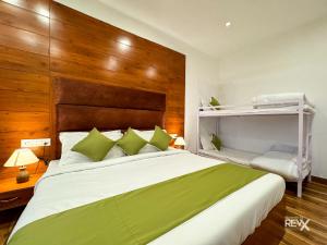 una camera da letto con un grande letto bianco con cuscini verdi di Hotel Wraveler Inn Mussoorie a Mussoorie