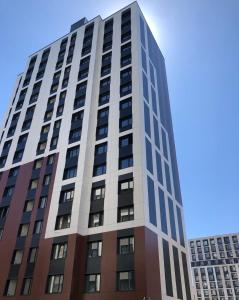 TaldykolʼにあるEasy Apartの側面に窓がある高い建物