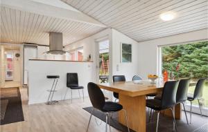 a kitchen and dining room with a wooden table and chairs at Holiday Home Agertoften Løkken V in Løkken